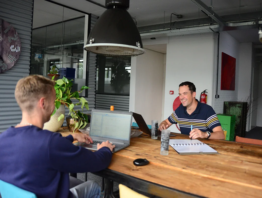 Het En Masse team in overleg aan de grote houten tafel
